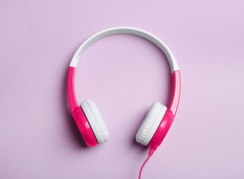 Stylish headphones on color background, top view