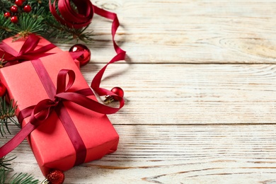 Photo of Gift boxes, Christmas balls and festive decor on white wooden table. Space for text