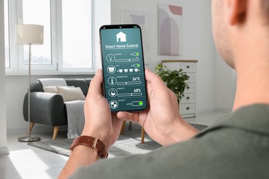 Image of Man using smart home control system via application on mobile phone indoors, closeup
