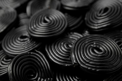 Photo of Tasty black liquorice candies as background, closeup