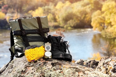 Set of camping equipment on rock outdoors. Space for text