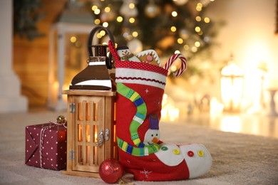 Photo of Stocking, sweets, gift box and lantern on table. Saint Nicholas Day tradition