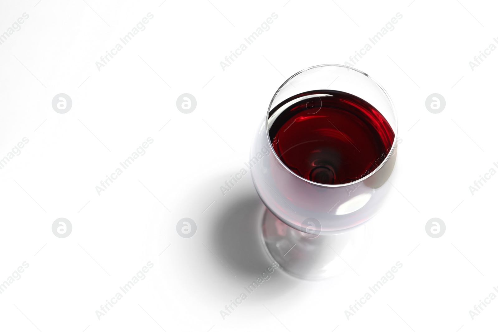 Photo of Glass of red wine on white background, above view. Space for text