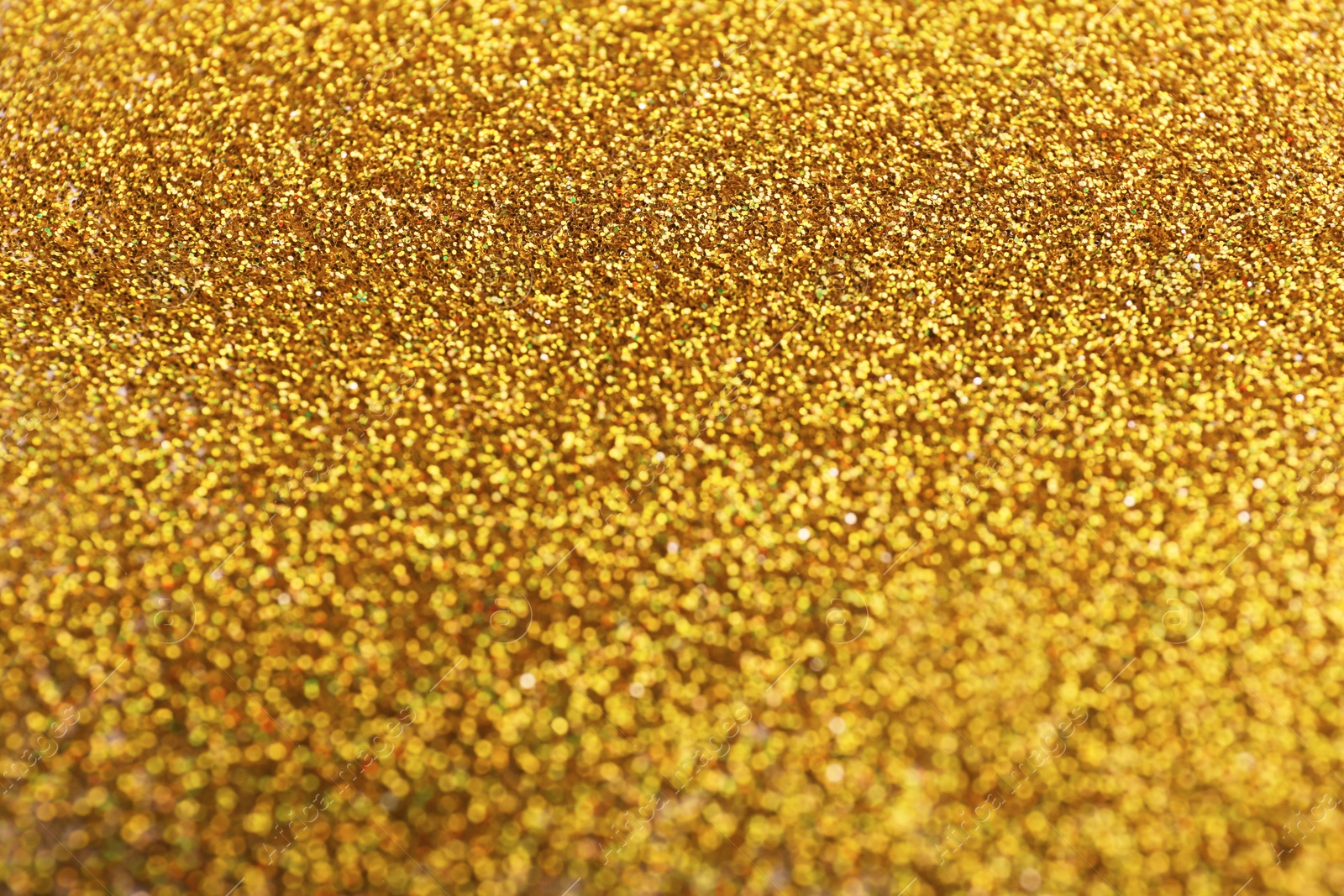 Photo of Closeup view of sparkling golden glitter background