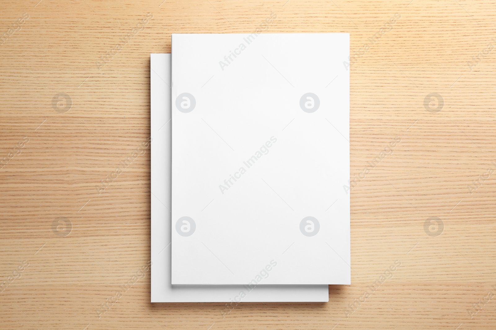 Photo of Stack of blank paper sheets for brochure on wooden background, top view. Mock up