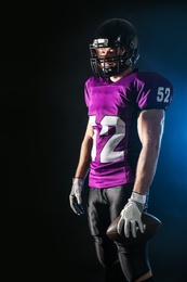 Photo of American football player with ball on dark background