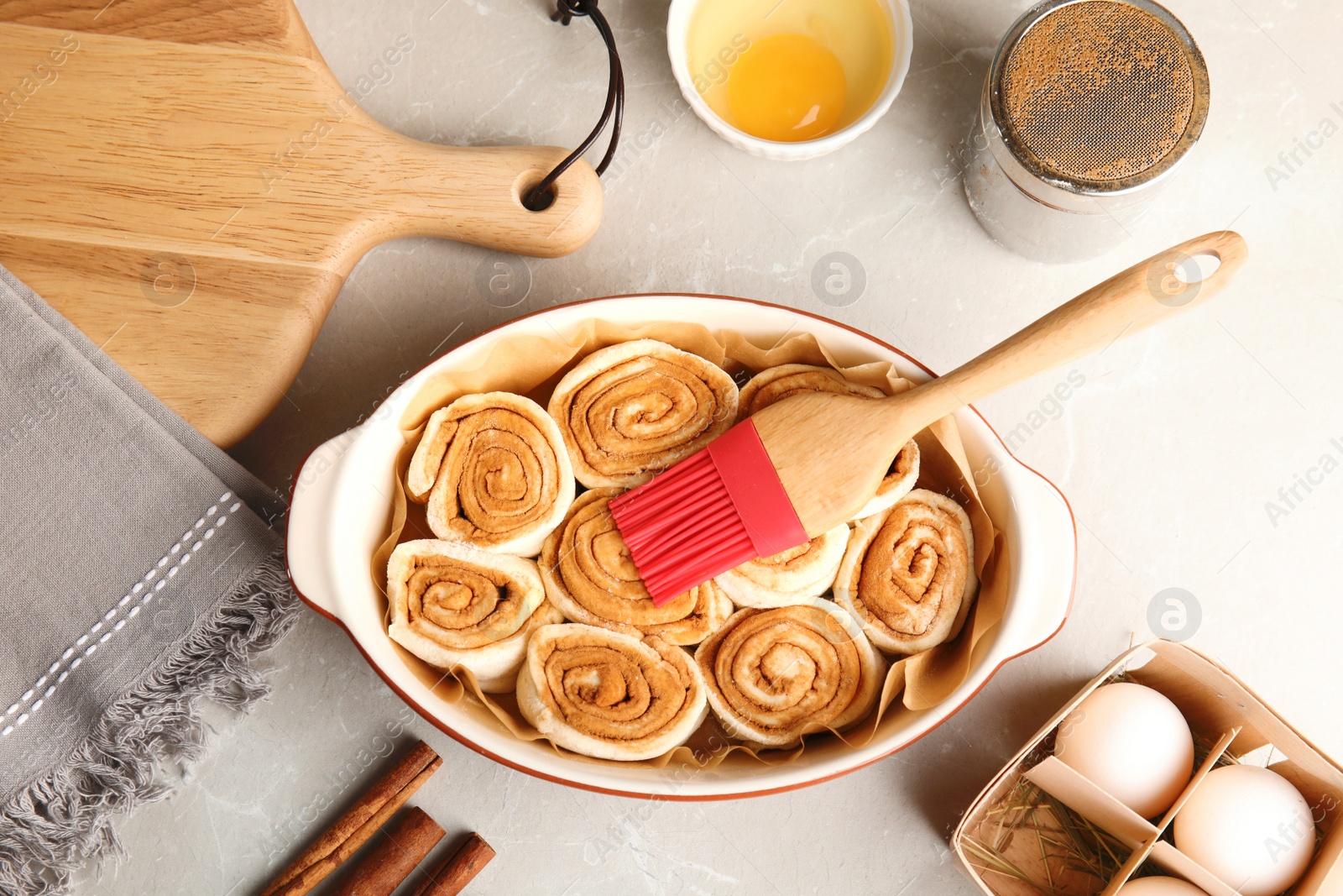 Photo of Flat lay composition with raw cinnamon rolls on grey background