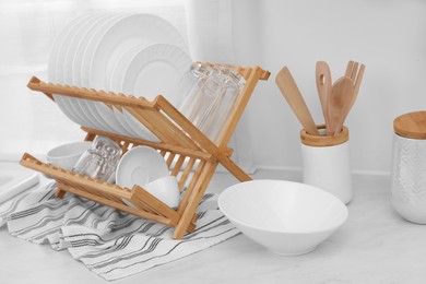 Photo of Drying rack with clean dishes on light table