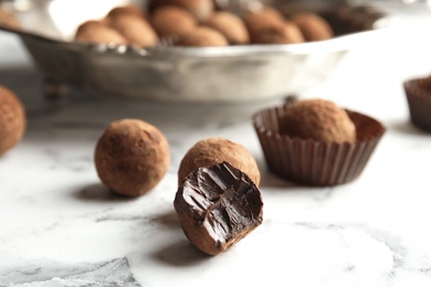 Photo of Tasty raw chocolate truffles on marble table