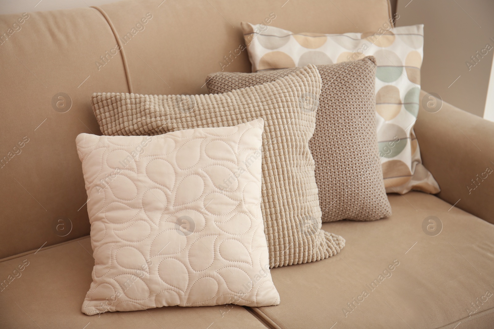 Photo of Different soft pillows on sofa in room