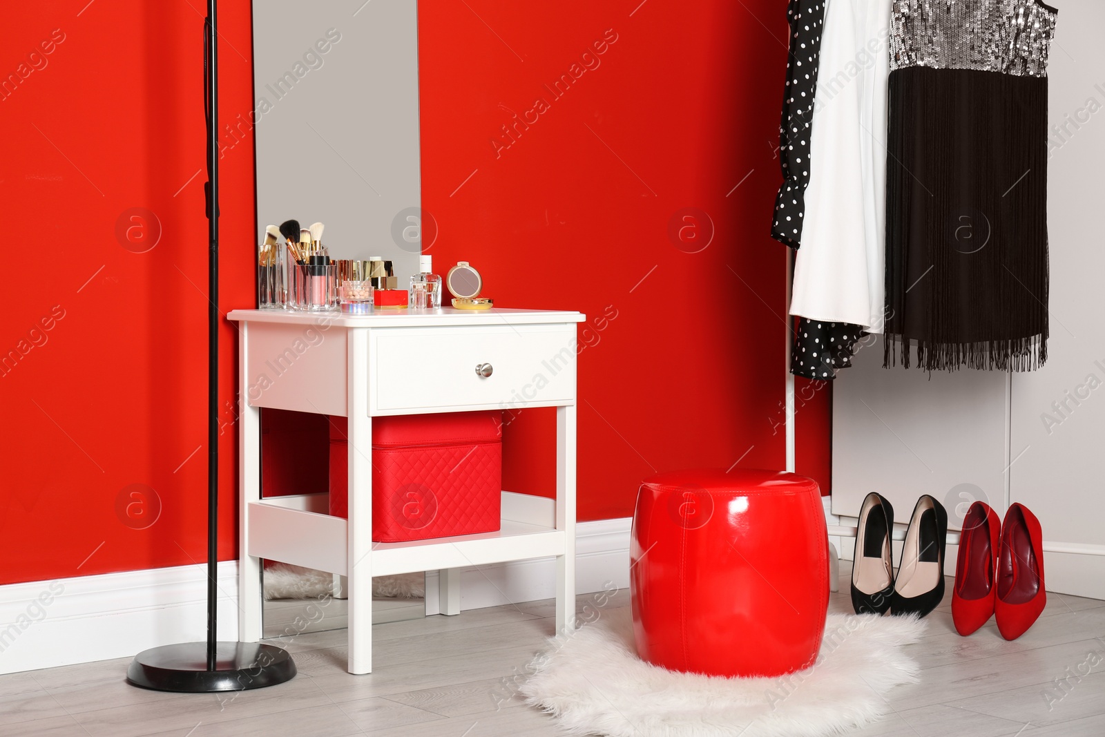 Photo of Stylish room interior with set of makeup products on dressing table