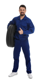 Full length portrait of professional auto mechanic with wheel on white background