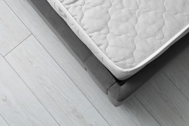 Photo of New soft mattress on grey bed indoors, top view. Space for text