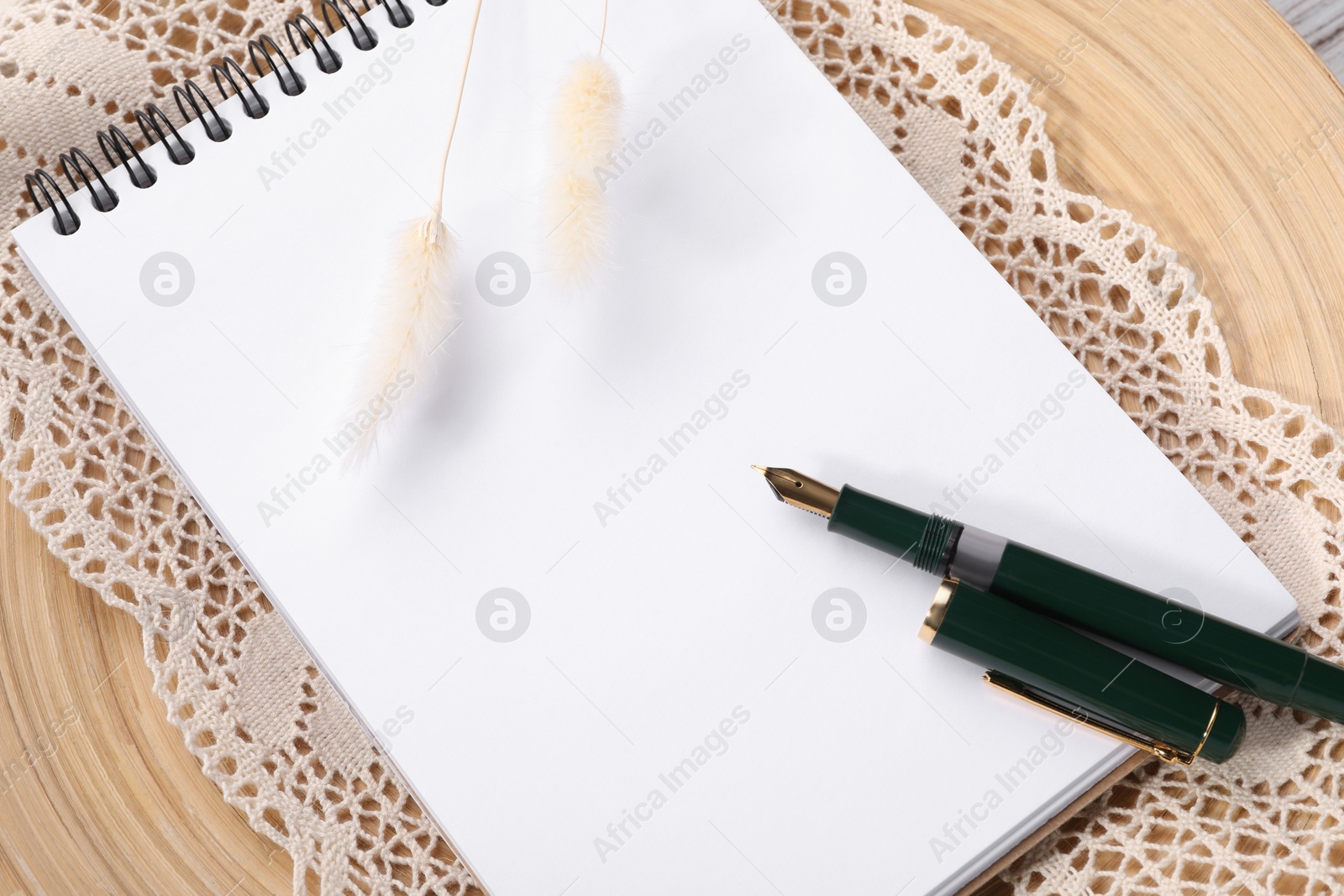 Photo of Guest list. Notebook, pen, spikelets and lace ribbon on wooden background, above view