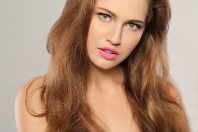 Photo of Young woman wearing beautiful lipstick on gray background