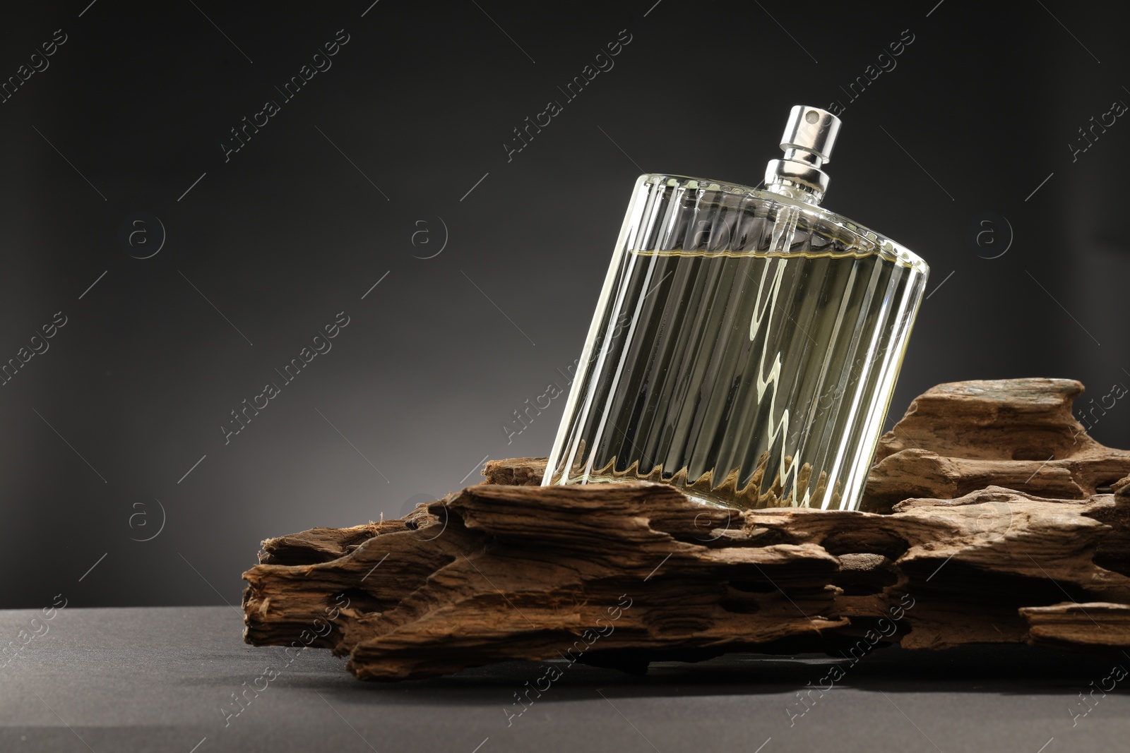 Photo of Luxury men`s perfume in bottle on grey table, space for text