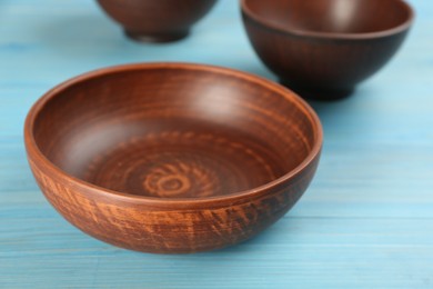 Clay bowl on light blue wooden table, closeup