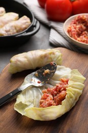 Photo of Preparing stuffed cabbage rolls on grey table, closeup