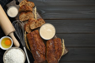 Photo of Flat lay composition with freshly baked bread and sourdough on wooden table. Space for text