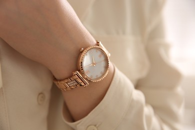 Photo of Woman with luxury wristwatch on light background, closeup