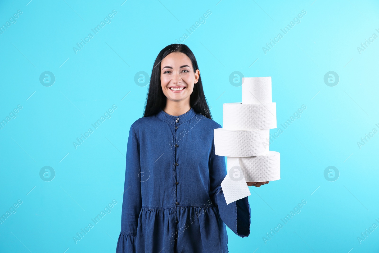 Photo of Beautiful woman holding toilet paper rolls on color background