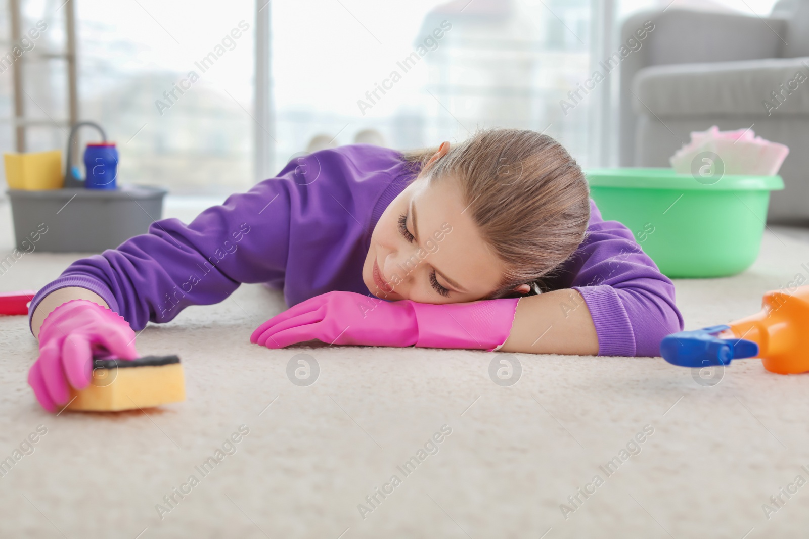 Photo of Tired woman after cleaning carpet sleeping on floor at home