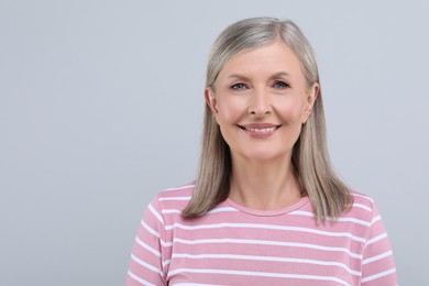 Portrait of beautiful senior woman on light grey background. Space for text