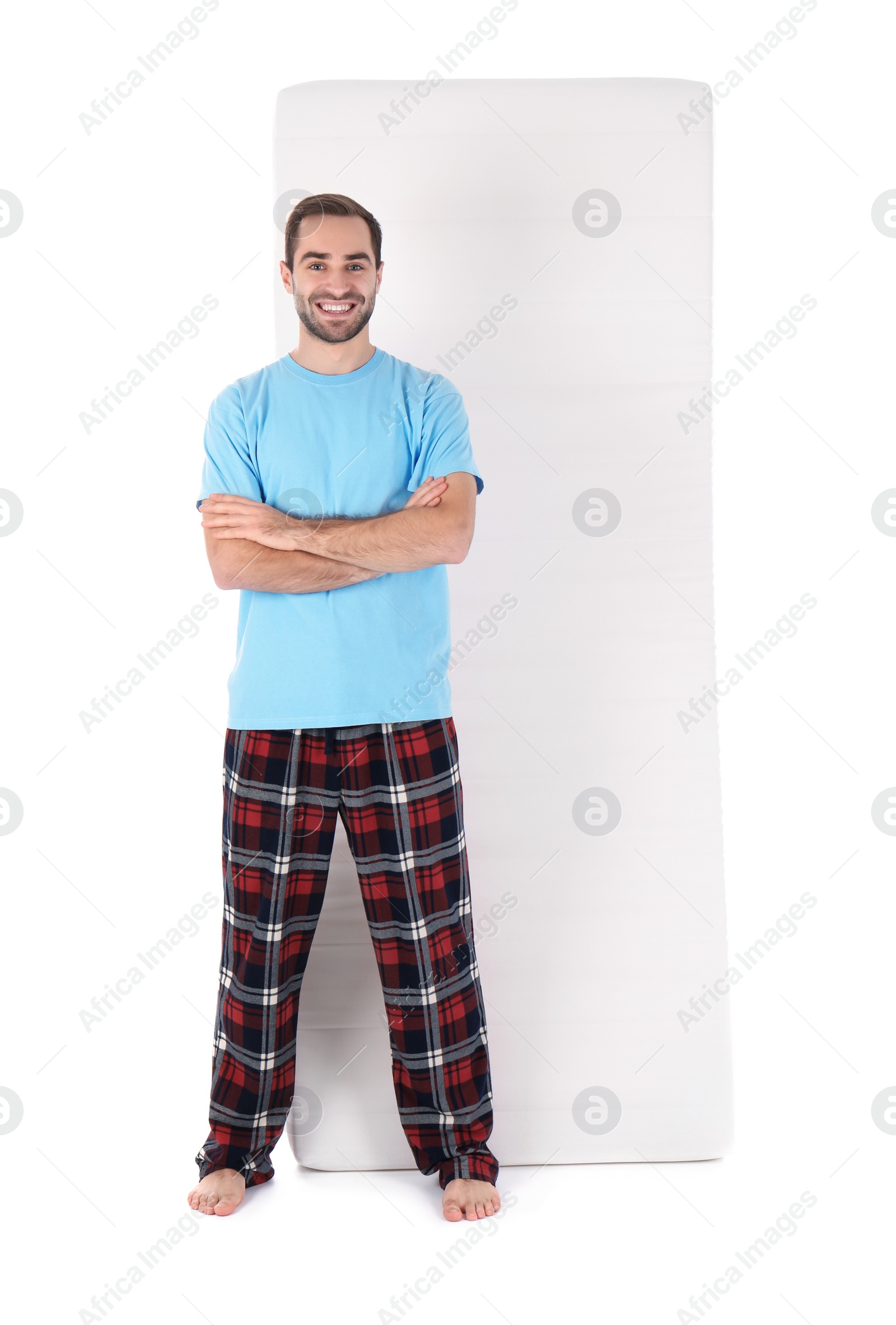 Photo of Young man with comfortable mattress isolated on white