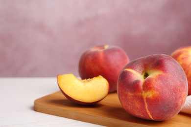 Photo of Board with fresh peaches on white table. Space for text