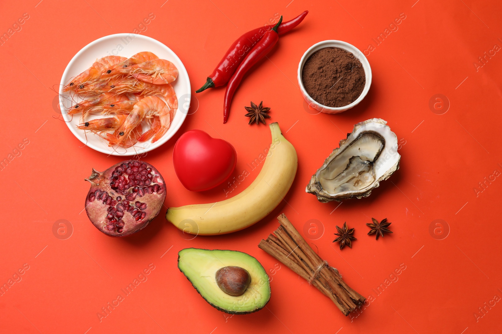 Photo of Natural aphrodisiac. Different food products and red decorative heart on orange background, flat lay