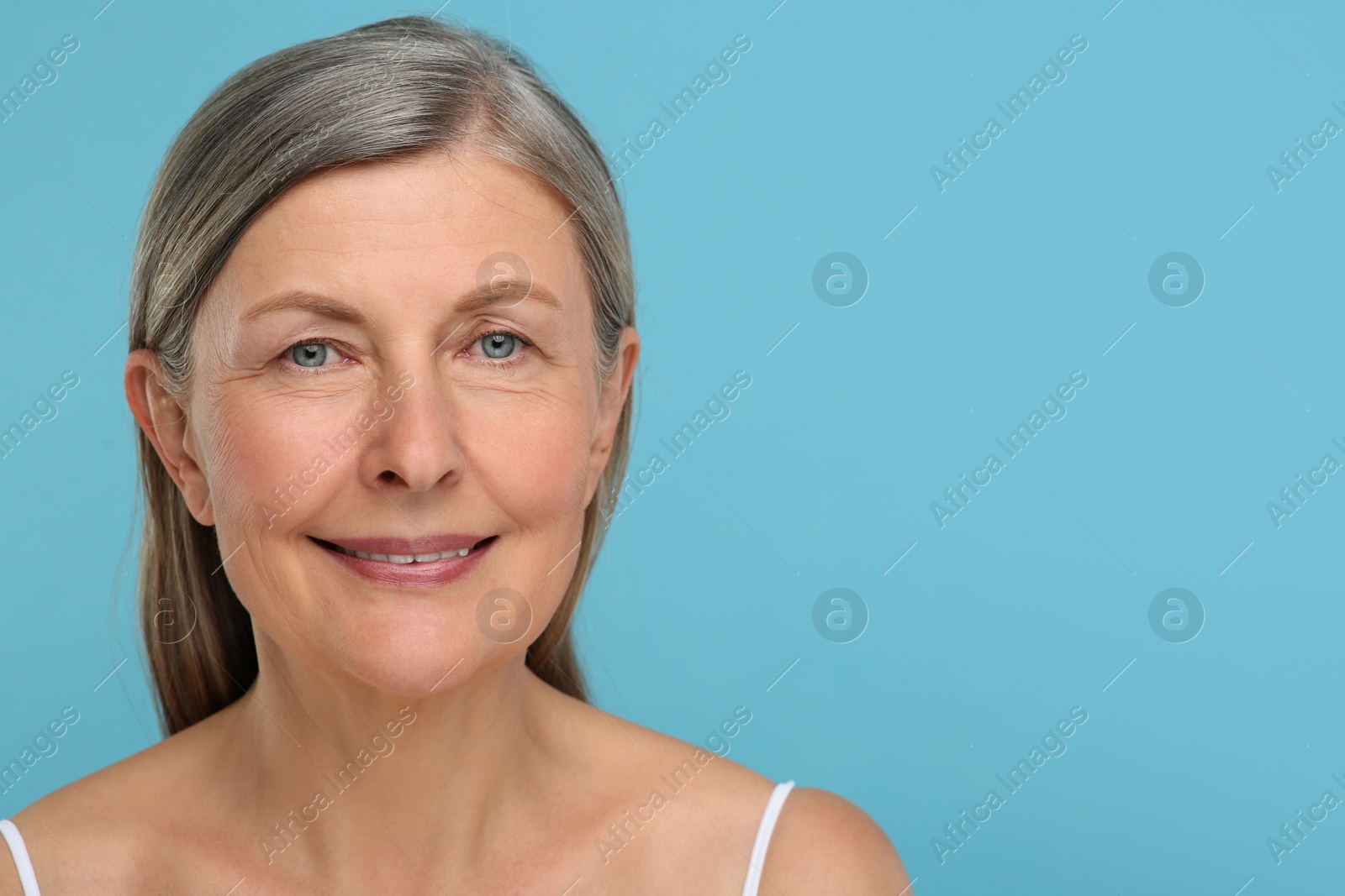 Photo of Portrait of senior woman with aging skin on light blue background, space for text. Rejuvenation treatment