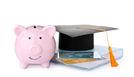 Photo of Graduation hat, credit cards, book and piggy bank isolated on white