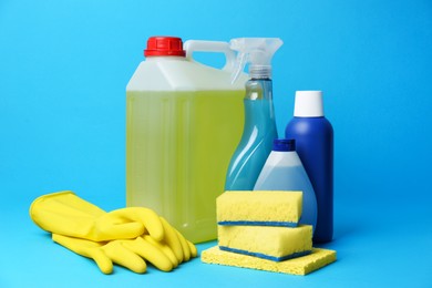 Cleaning supplies and tools on light blue background