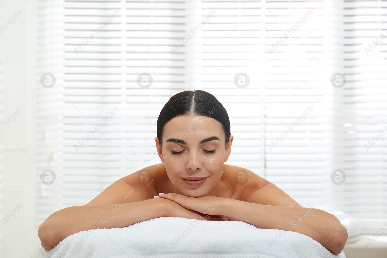 Photo of Beautiful young woman relaxing in spa salon