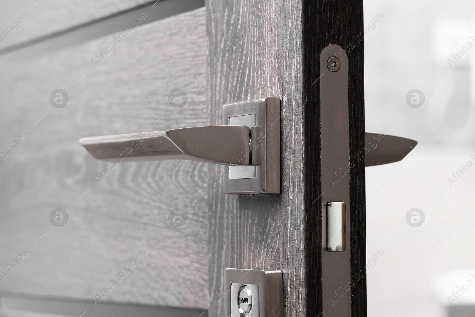 Photo of Open wooden door with metal handle, closeup