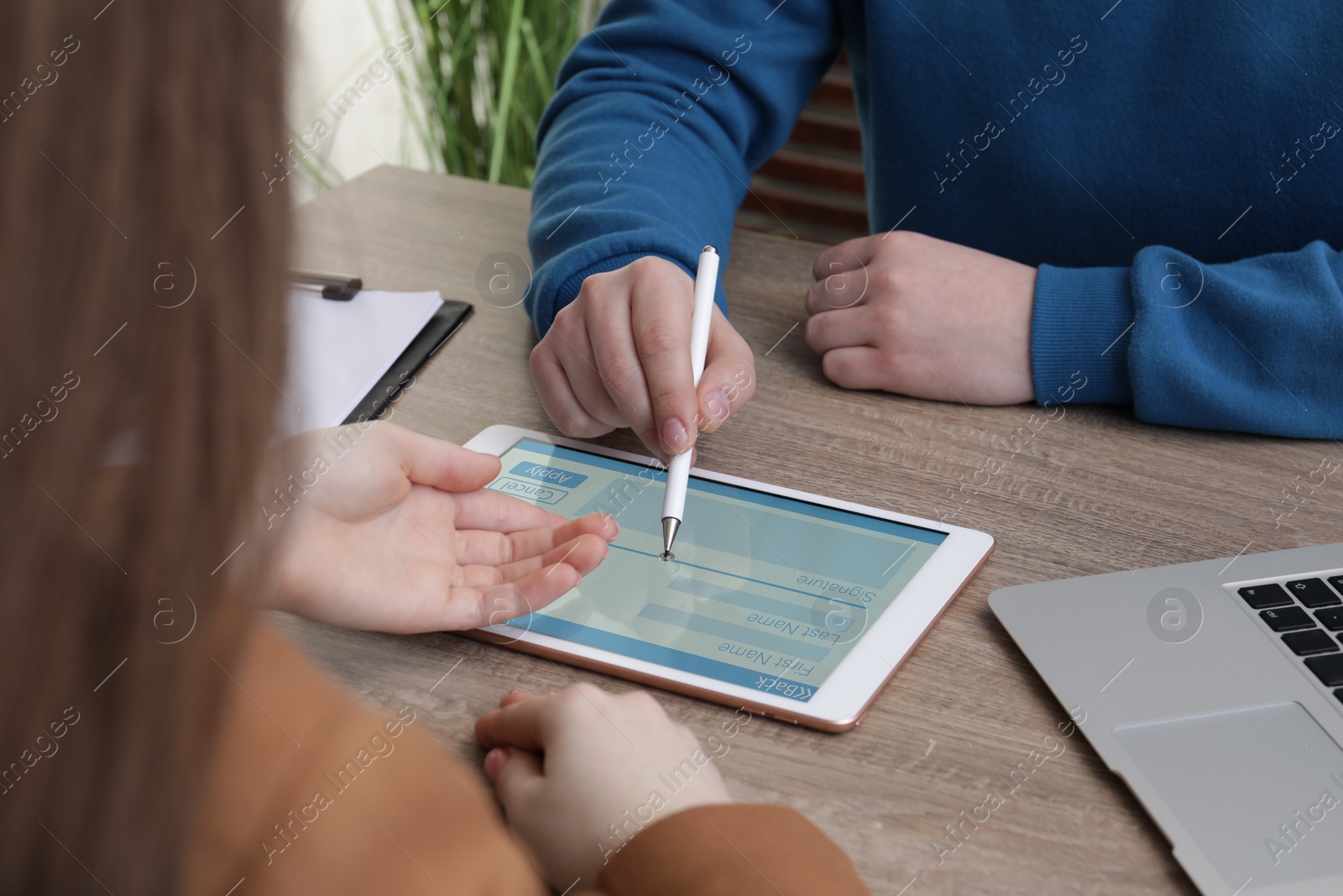 Image of Electronic signature. Man using stylus and tablet at wooden table, closeup