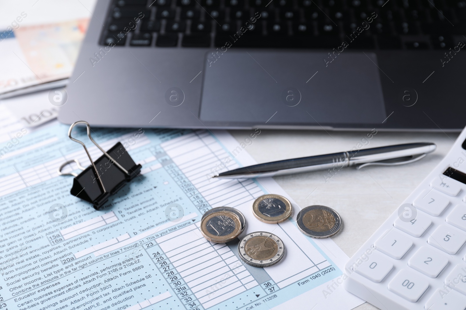 Photo of Tax accounting. Stationery, money, document, laptop and calculator on light grey table, closeup