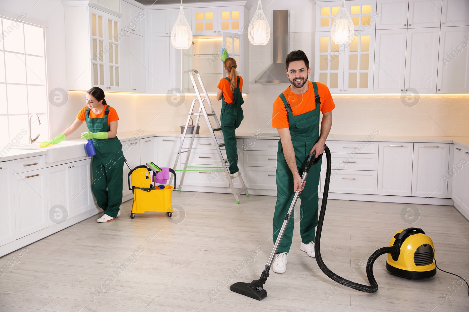 Photo of Team of professional janitors cleaning modern kitchen