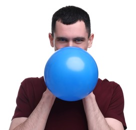 Young man inflating light blue balloon on white background