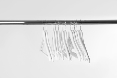 Metal rack with clothes hangers on white background