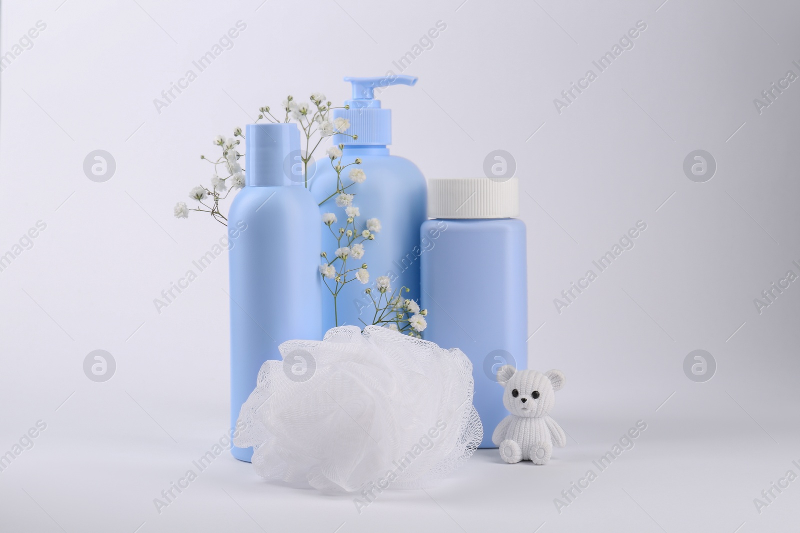 Photo of Different skin care products for baby, shower puff and toy on white background