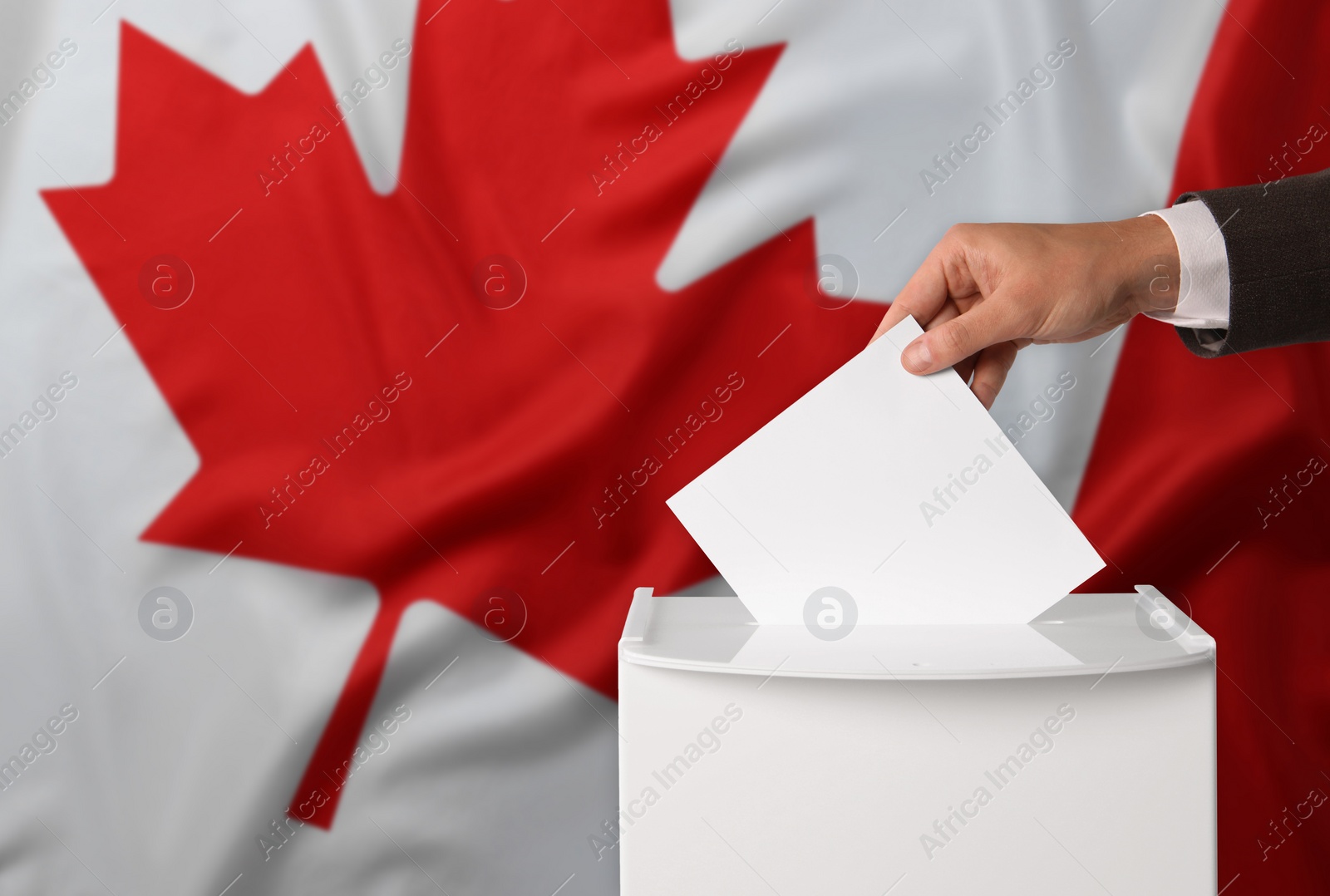 Image of Man putting his vote into ballot box against national flag of Canada, closeup. Space for text