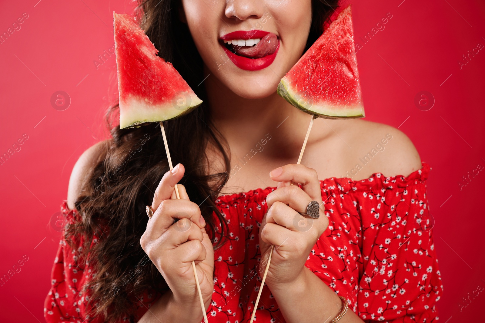 Photo of Beautiful young woman with watermelon on red background, closeup