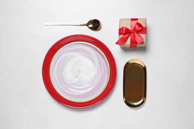 Photo of Flat lay composition with dishware and gift on white table