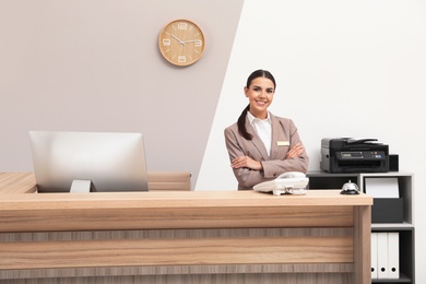 Portrait of receptionist at desk in modern hotel