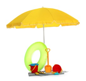 Beach umbrella, inflatable ring, towel and child's sand toys on white background
