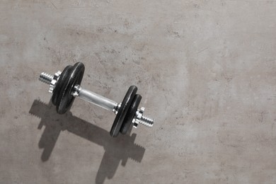 Photo of One barbell on grey floor, top view. Space for text