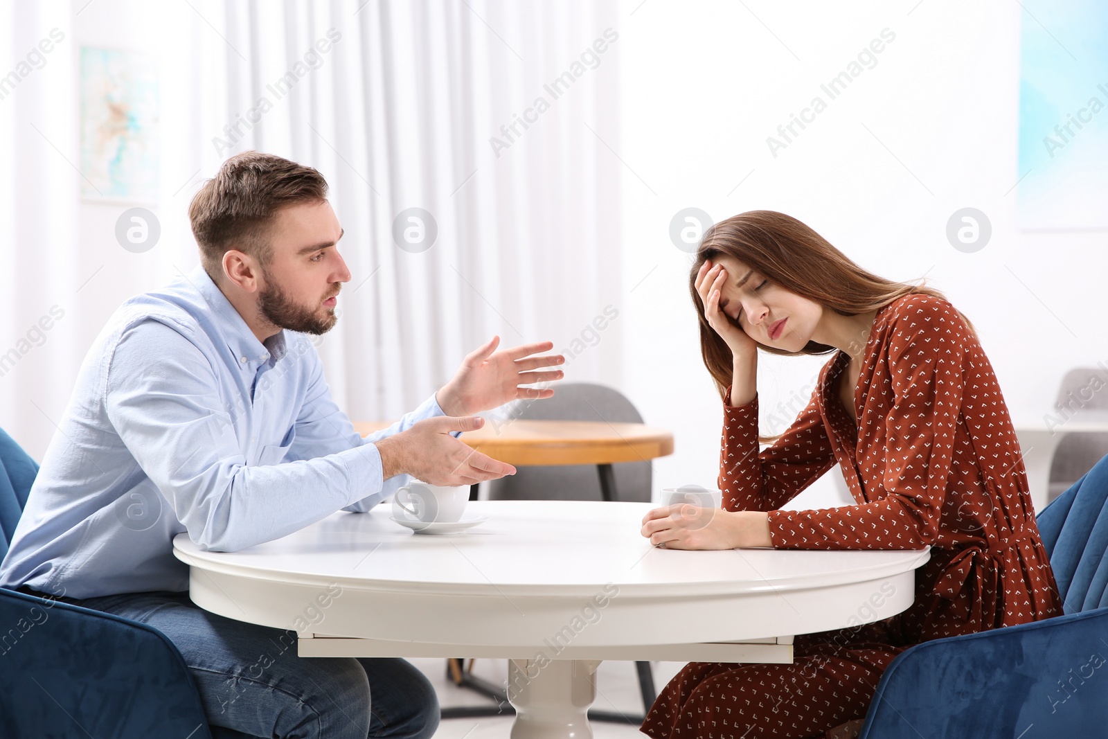 Photo of Couple having quarrel in cafe. Relationship problems