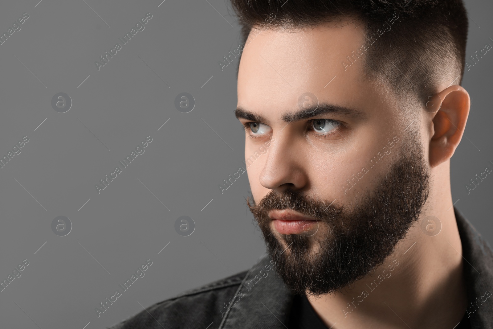 Photo of Portrait of young man with mustache on grey background. Space for text