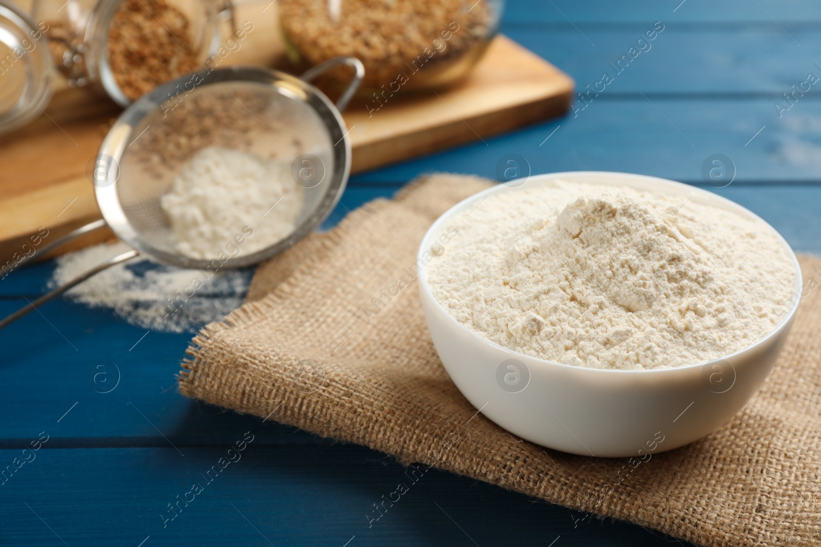 Photo of Bowl of flour on blue wooden table